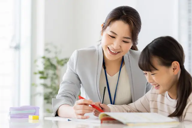 女の子に勉強を教える大人の女性