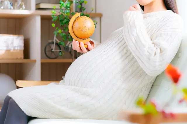 小さな地球儀をもつ妊婦さん