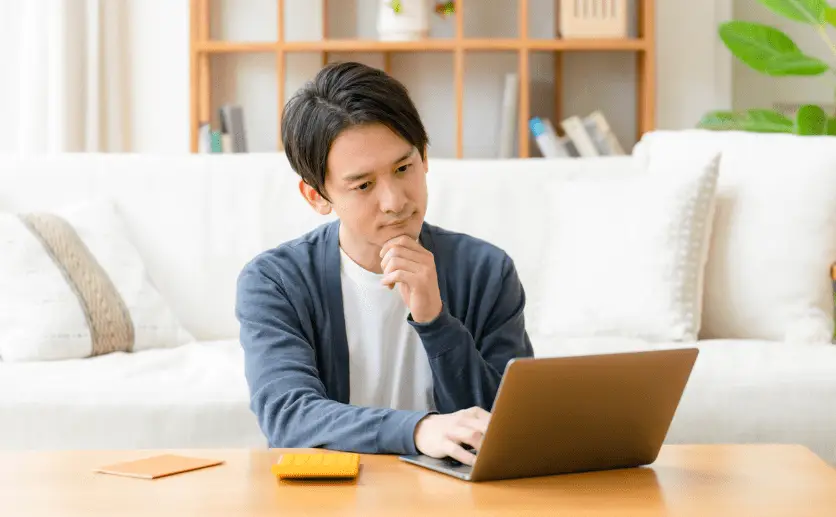 パソコンの前で悩む男性